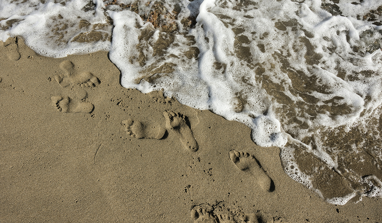 footprints near the ocean