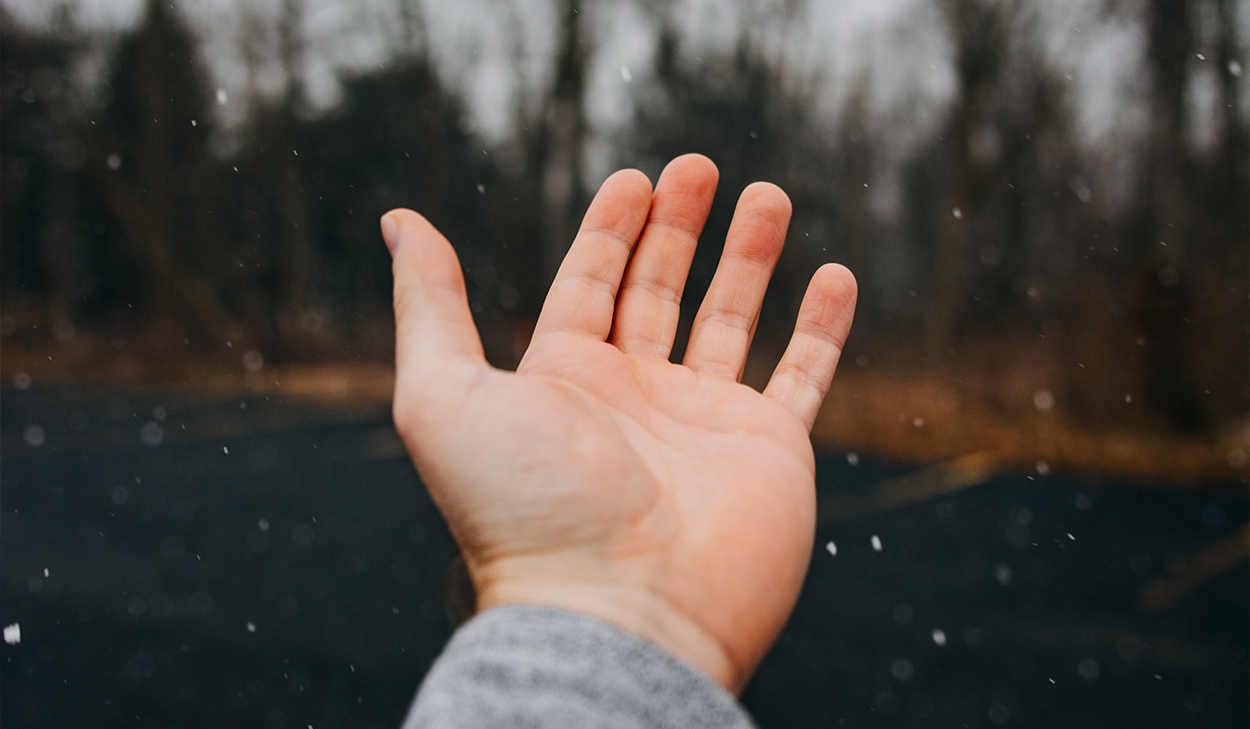 Hand in falling snow