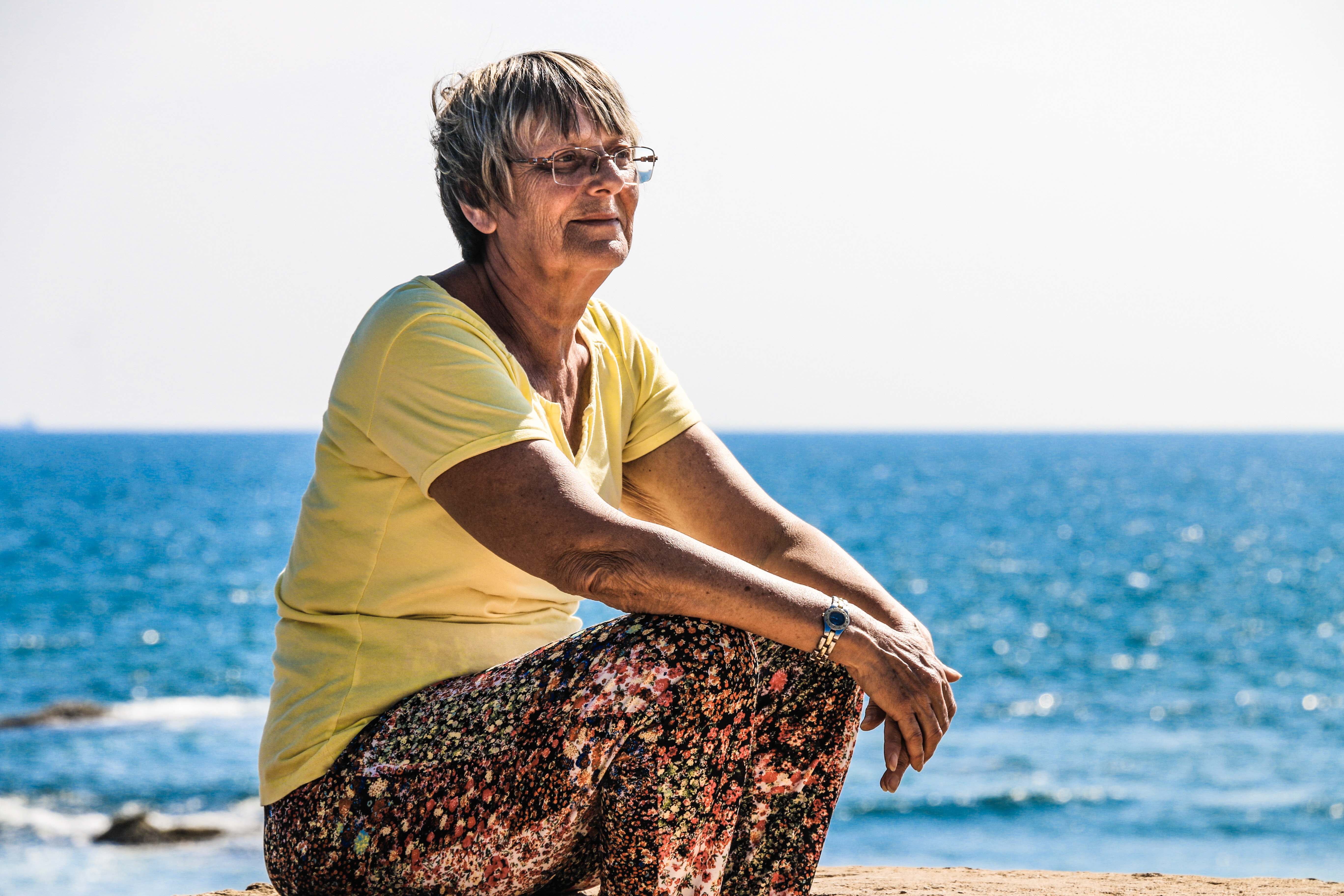 Woman sitting by the ocean