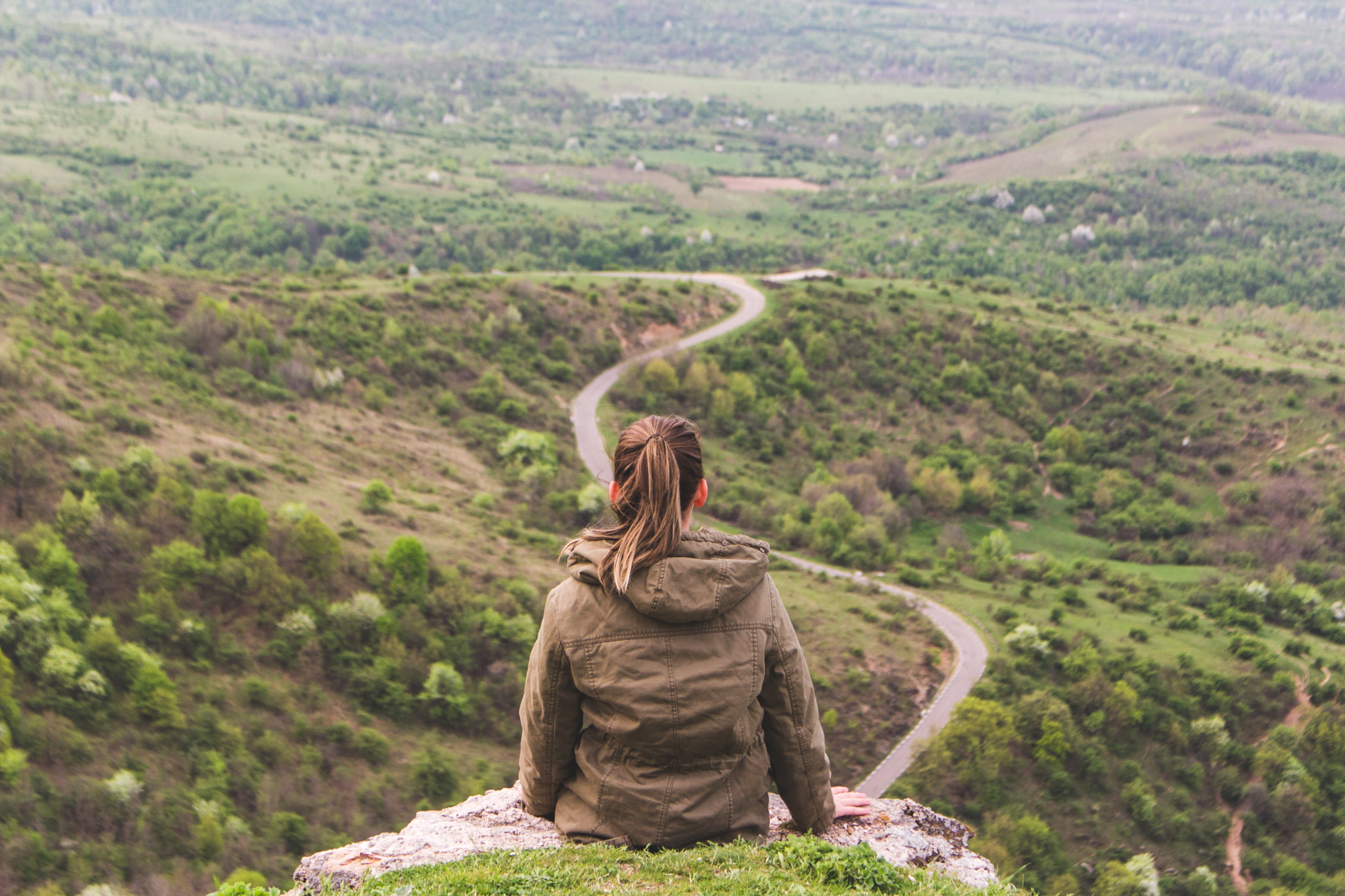 Woman on a cliff looking at a road