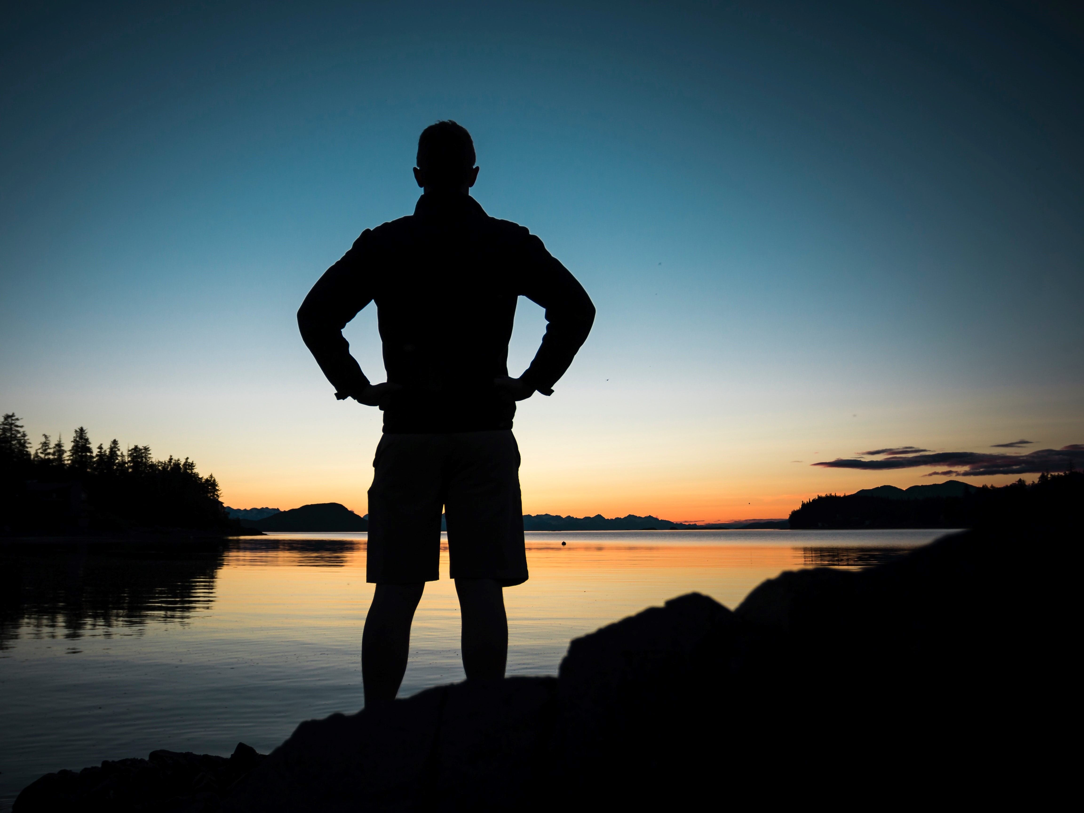 Male silhouette over a lake